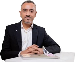 Dr Ameet Parekh sitting at a table with a laptop.